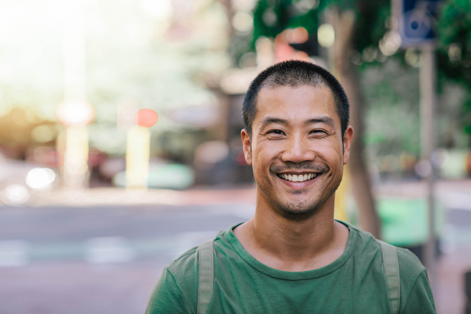 Young Asian man smiling confidently on a city street Young Asian man smiling confidently on a city street